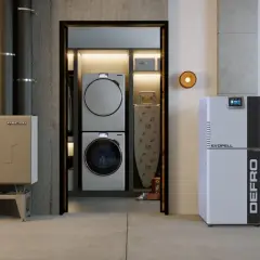 Nowoczesny kocioł co z podajnikiem 15 kW marki DEFRO, obok pralki i suszarki w pralni.