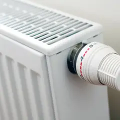 Biały grzejnik z termostatem, idealny do domu. Zastanawiasz się, jakie grzejniki elektryczne do domu wybrać?