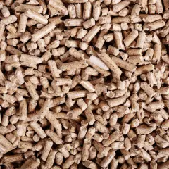 Mnóstwo drobnych, cylindrycznych granulek, czyli pelletu, tworzy gęstą, brązową masę.