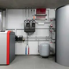 Nowoczesna kotłownia z kotłem 50 kW, zasobnikiem ciepłej wody i rozdzielaczem ogrzewania podłogowego.