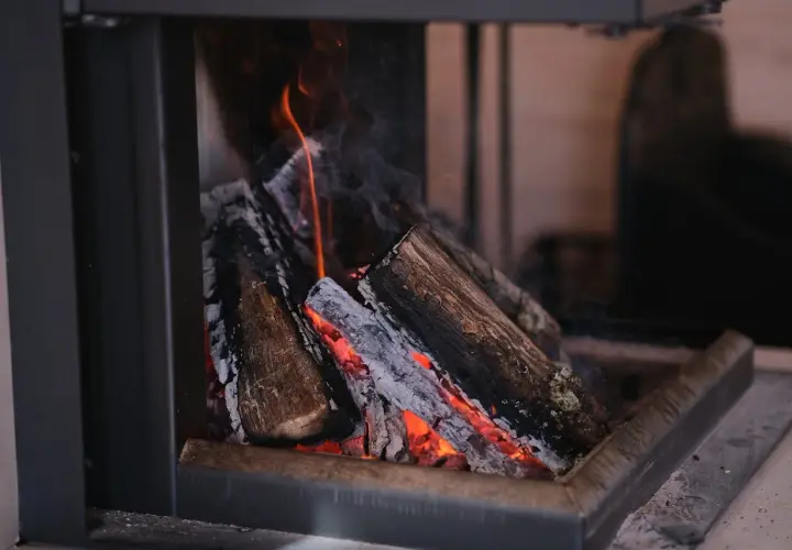 Płonące drewno w kominku, żar rozświetla popiół. To idealne rozwiązanie dla tych, którzy szukają wydajnych kotłów co 5 klasy.