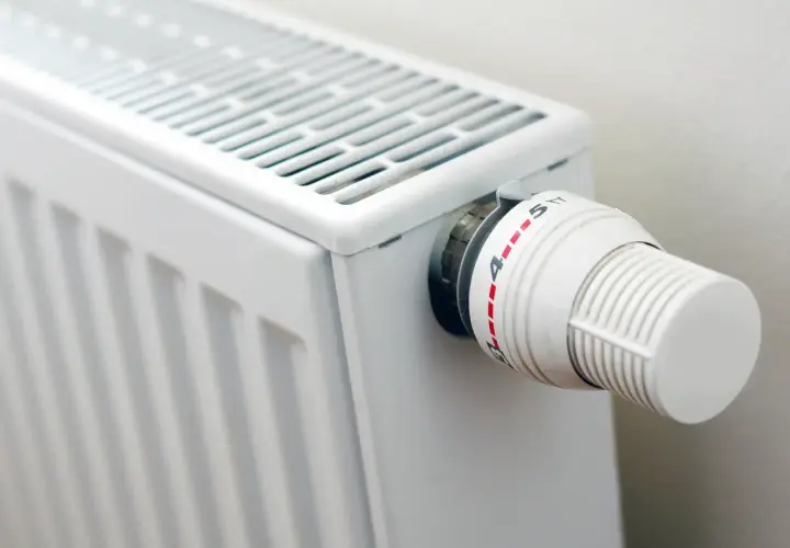 Biały grzejnik z termostatem, idealny do domu. Zastanawiasz się, jakie grzejniki elektryczne do domu wybrać?