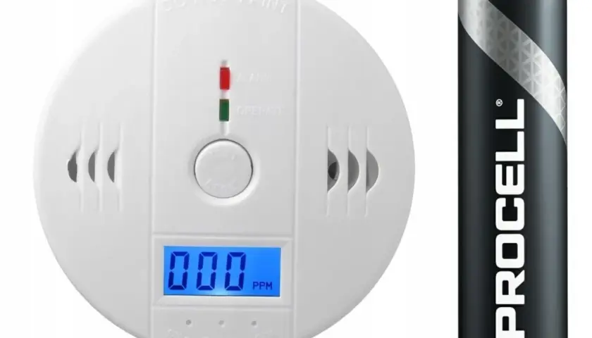 Biały czujnik czadu z wyświetlaczem pokazuje 000 PPM, obok bateria Procell.