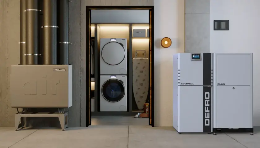 Nowoczesny kocioł co z podajnikiem 15 kW marki DEFRO, obok pralki i suszarki w pralni.