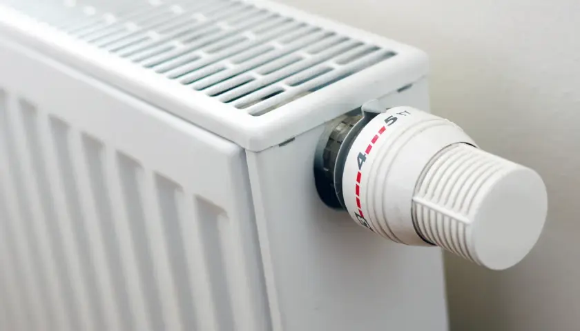 Biały grzejnik z termostatem, idealny do domu. Zastanawiasz się, jakie grzejniki elektryczne do domu wybrać?