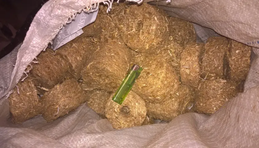 Worek pełen brykietów ze słomy, które można zrobić samodzielnie. Zielona zapalniczka pokazuje ich rozmiar.