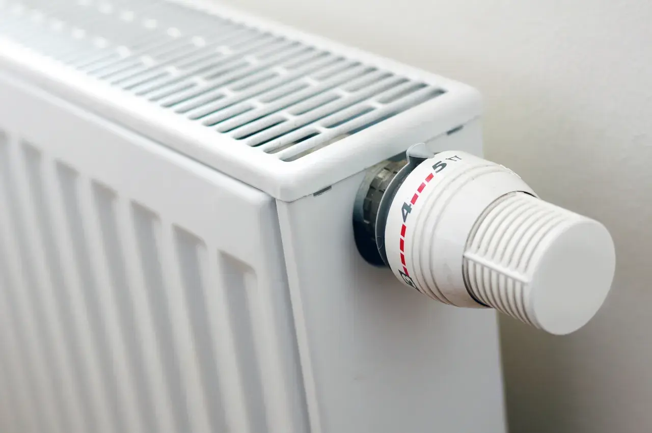 Biały grzejnik z termostatem, idealny do domu. Zastanawiasz się, jakie grzejniki elektryczne do domu wybrać?
